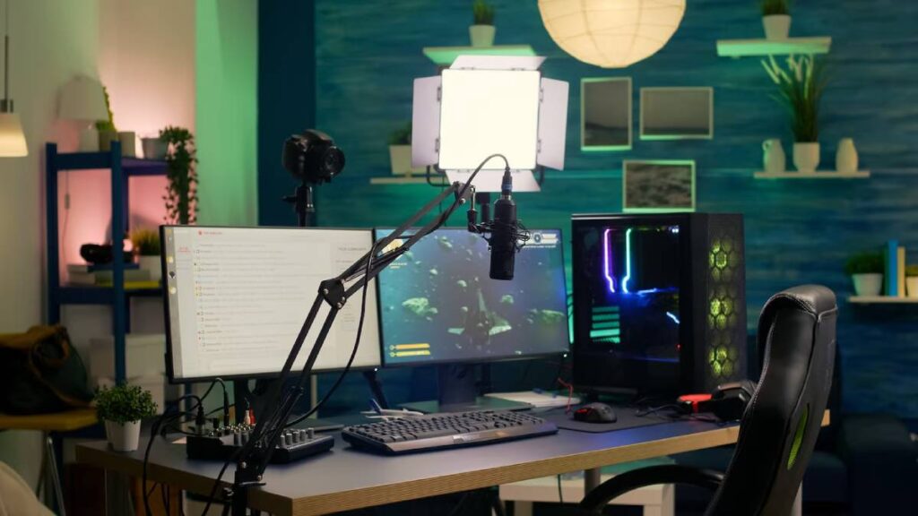 A modern gaming setup featuring dual monitors, a microphone, webcam, and RGB gaming PC in a stylish, well-lit room.