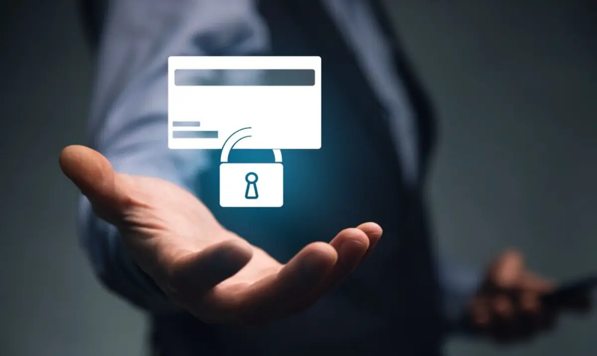 A businessman holds out a hand with a digital credit card icon and a padlock, symbolizing secure online transactions.