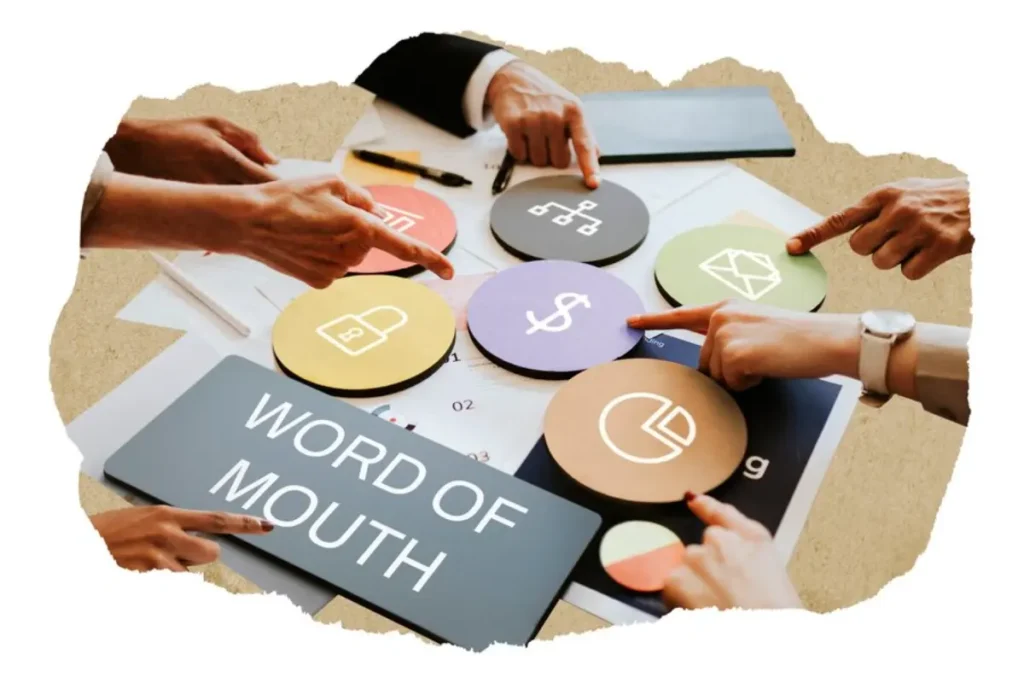 Hands point to colorful strategy icons on a table, with WORD OF MOUTH prominently displayed on a grey sign.