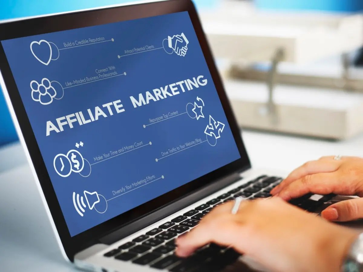 A person typing on a laptop displaying an Affiliate Marketing infographic, highlighting strategies for successful online marketing.