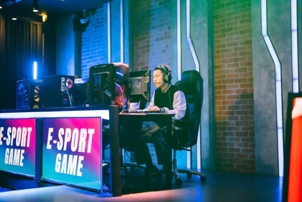 A gamer in a stylish gaming chair focuses intently on the screen, surrounded by colorful lights and high-tech equipment in an esports setting.