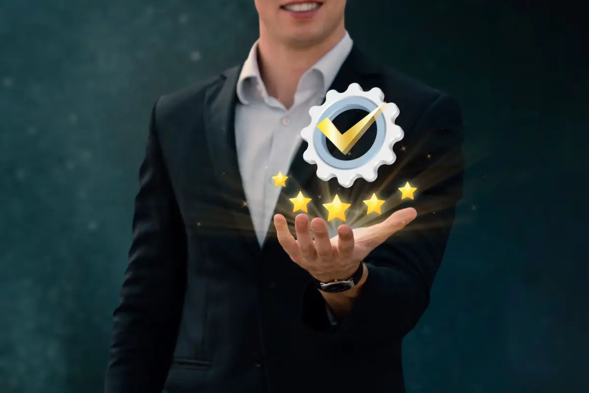 A man in a suit holds out his hand, displaying a gear with a checkmark and glowing stars, symbolizing quality and success.