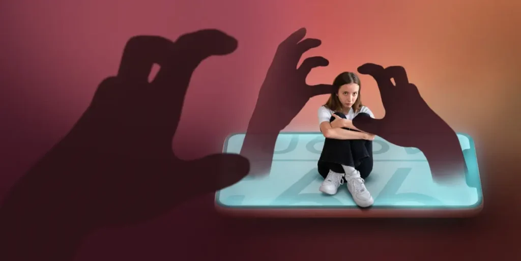 A child sits curled up on a phone, with looming shadows of hands reaching out menacingly, symbolizing online threats and dangers.