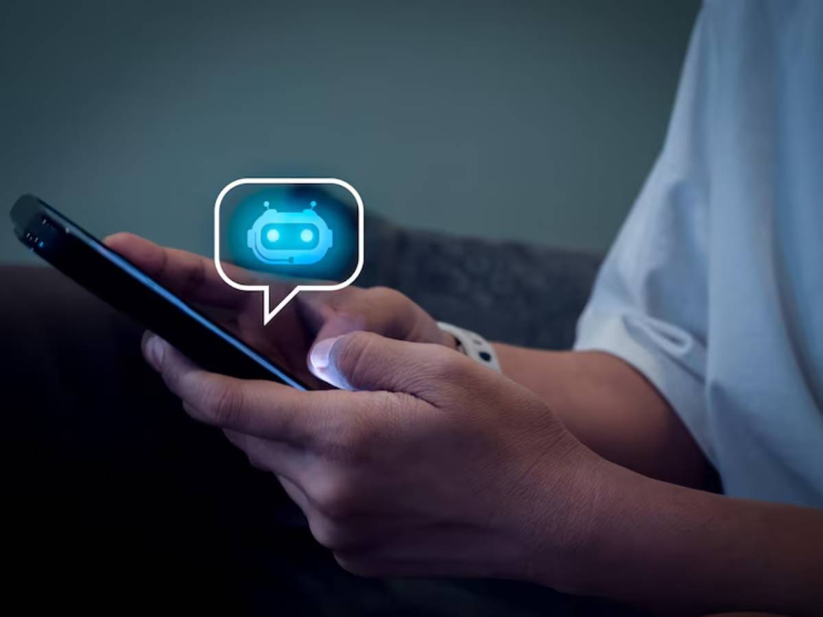 A person holds a smartphone displaying a chatbot icon in a speech bubble, emphasizing digital communication.